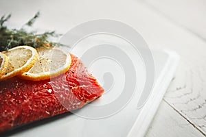 Calling all carnivores. a raw piece of meat garnished with slices of lemon.