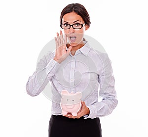 Calling businesswoman holding pink piggy bank