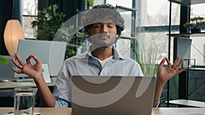 Calm Arabian latin man Indian businessman meditate at office desk zen meditation relaxed male business CEO employer