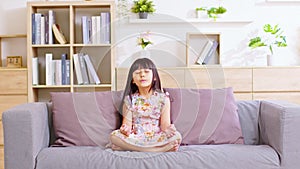 Calm of Asian child cute making yoga meditation with inhale and exhale. Sit on couch for focusing mind and soul. Relaxed with hand