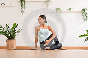 Calm of Asian woman in sportwear stretching muslce to warm up breathing and meditation with yoga at home.Healthy female doing yoga