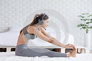 Calm of Asian woman in sportwear stretching muslce to warm up breathing and meditation with yoga at home.Healthy female doing yoga