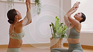 Calm of Attractive two Asian woman friend practice yoga Eagle or Garudasana pose to stretching and meditation at home comfortable