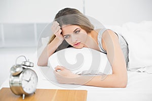 Calm attractive woman lying thoughtful on her bed