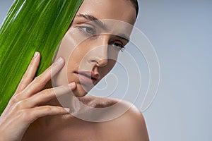 Calm attractive young woman with green plant photo