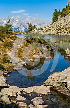 Calm autumn Alps mountain lake with clear transparent water and reflections. Spiegelsee or Mirror Lake, Reiteralm, Steiermark,