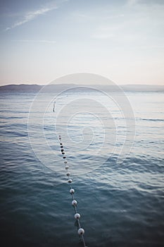 Calm background with views of the sea and the far shore. dividing buoys in the swimming area