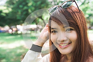 Calm beautiful smiling young woman with ponytail enjoying fresh air outdoor.