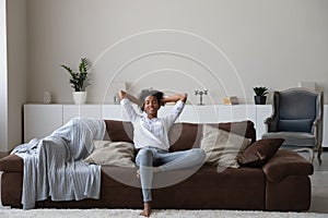 Calm biracial woman relax on cozy couch at home