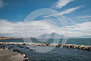 Calm blue Tyrrhenian Sea. View from the embankment of Naples to Mount Vesuvius volcano. Pleasure boats moored near the stone