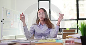 Calm business woman doing yoga at workplace