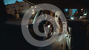 Calm business woman talking on smartphone in dark salon of business car.