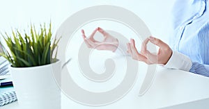 Calm businesswoman meditating at work, focus on female hands in mudra, close up view. Peaceful mindful employee
