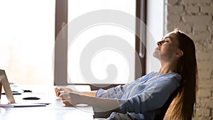 Calm businesswoman relaxing in comfortable office chair at work