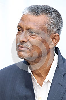 Calm or casual looking senior Indian man face portrait on white background.  Old man looking side way.