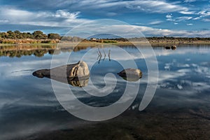 Calm and clear lake with the reflection of the cloudy sky photo