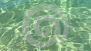 Calm clear transparent sea water rippled surface background and sunlight