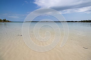 Calm clear water on a tropical beach on a cloudy day in Bahamas