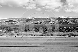 Calm desert highway empty road nowhere lonely black white mountains clouds dry adventure climate