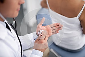 Calm doctor putting stethoscope on his hand