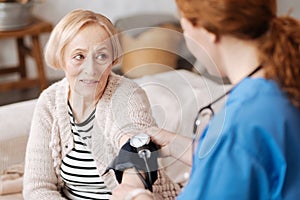 Calm elderly lady having her blood pressure checked