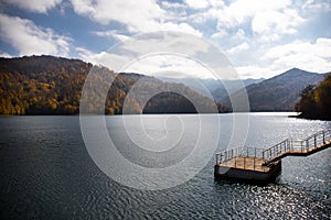 A calm evening landscape with lake and mountains. Amazing view of the Goy-Gol (Blue Lake) Lake among colorful fall forest at Ganja