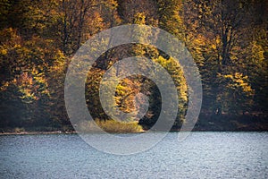 A calm evening landscape with lake and mountains. Amazing view of the Goy-Gol (Blue Lake) Lake among colorful fall forest at Ganja