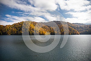 A calm evening landscape with lake and mountains. Amazing view of the Goy-Gol (Blue Lake) Lake among colorful fall forest at Ganja