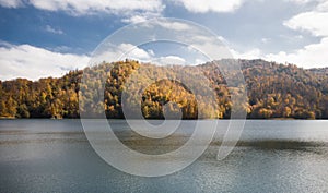 A calm evening landscape with lake and mountains. Amazing view of the Goy-Gol (Blue Lake) Lake among colorful fall forest at Ganja