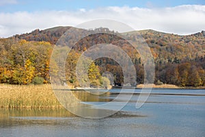 A calm evening landscape with lake and mountains. Amazing view of the Goy-Gol (Blue Lake) Lake among colorful fall forest at Ganja