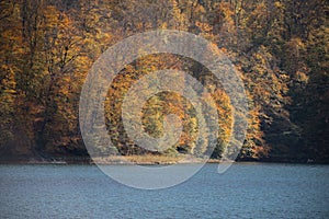 A calm evening landscape with lake and mountains. Amazing view of the Goy-Gol (Blue Lake) Lake among colorful fall forest at Ganja