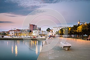 A calm evening promenade by the sea in the harbor of Koper, Slovenia after sunset