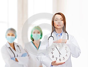 Calm female doctor with wall clock