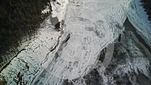 Calm, frozen river covered with ice on cold winter day. Peaceful river water and snowy coast on cold gray day in winter