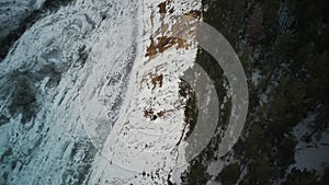 Calm, frozen river covered with ice on cold winter day. Peaceful river water and snowy coast on cold gray day in winter