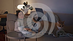 Calm girl looking computer screen relaxing at night couch. Woman lying at home