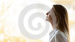 Calm happy business woman breathing fresh air stand at window