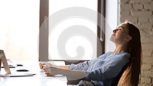 Calm businesswoman relaxing in comfortable office chair at work photo