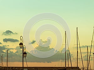 Calm harbor scene vintage lamp and ship masts sunset