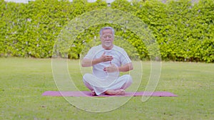 Calm of Healthy Senior Asian man wearing white shirt and pant doing Tai Chi Chuan for Meditation in Motion and breathe balance,