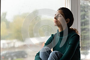 Calm Hispanic woman relax breathe fresh air