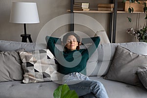 Calm hispanic woman take break for nap on soft couch