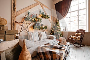 Calm image of interior modern home living room decorated christmas tree and gifts, sofa, table covered with blanket.