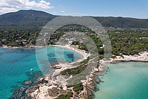 Calm Karydi beach near the village of Vourvourou in Greece. Aerial drive view of seashore and shallow see-through