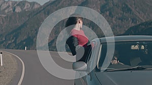 Calm lady with long hair enjoys life sitting on car window