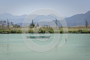 Calm lake with fishing boats. Fresh water lagoon in Estany de cullera. Valencia, Spain