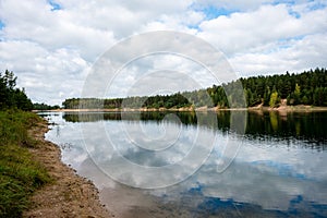 Calm lake with reflections of clouds in summer