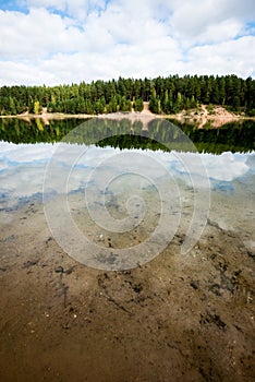Calm lake with reflections of clouds in summer