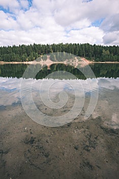 calm lake with reflections of clouds in summer- vintage retro l