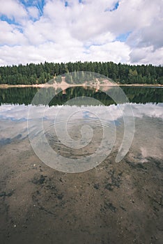 calm lake with reflections of clouds in summer- vintage retro l